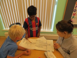 Rohit, Kieran, and Ms. Ainura discuss the human torso and estimate how many bones there are.